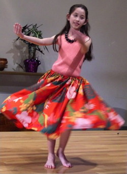 A young performer dances a hula