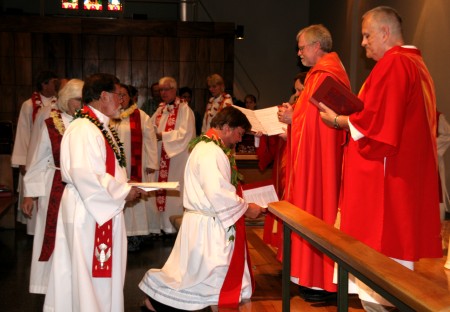 Pastor Jeff kneels as other Lutheran clergy gather in the laying-on-of-hands ritual.