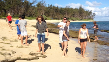 Campers hiking the beach at Mokule'ia