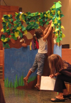 A child adds a symbol to the Jesse Tree