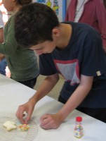 A child decorates his cookie.