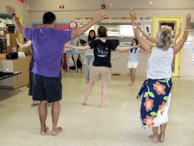 Young teachers (in the back, facing the camera) working with their hula students