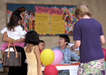 Parents and children gathered around the registration table table to register for the new year of LCH Sunday School