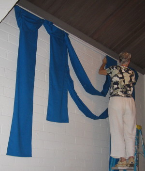 Carol Langner hanging a background for paper stars.