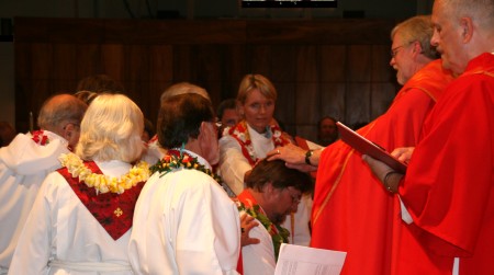 All the clergy lay hands on Pastor Lilley for the prayer of installation