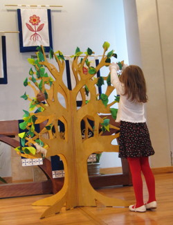 One of the children hangs the ladder for Jacob on the Jesse Tree