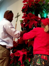 Walter Cummings and Peggy Anderson carefully select and place plants for the poinsettia tree