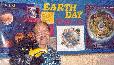 Deacon and Alala chat prior to worship in front of the Earth Day bulletin board.
