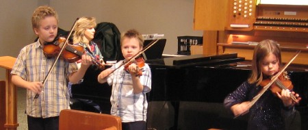 Three children offer music before worship