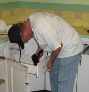 Pastor Jensen takes off the drawer pulls.