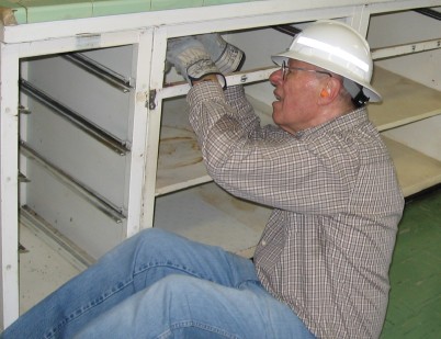 Don Person takes out screws holding the cabinets together.