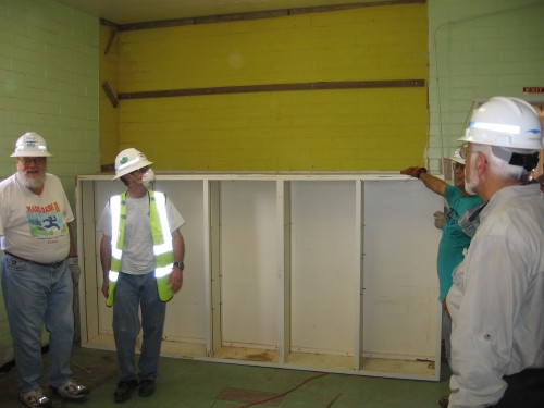 Workers check out the original paint after the upper cabinets were taken off the wall.