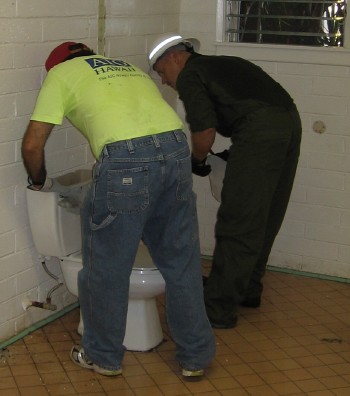 Randy Castello and and Steve Schmidt take out one of the commodes in the men’s rest room.