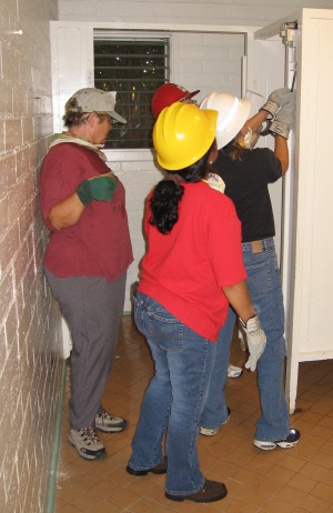 Linda Miller, Selena Schmidt, April Smith, and Dori Palcovich start removing the partition in the women’s rest room