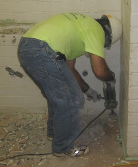 Randy Castello chipping tile in the men’s rest room.