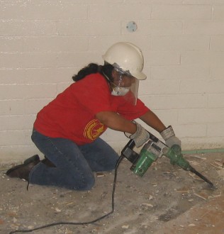 Selena Schmidt chipping tile in the women’s rest room.