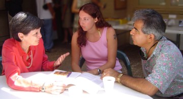 Josie Bidgood, Kelsey Megan Lloyd, and Francisco Barajas have a quick strategy meeting after church to plan the commitment visitation program.
