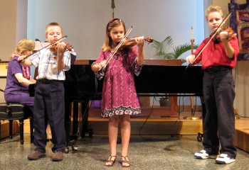 Three children joined together in “Allegro”by Shinichi Suzuki.