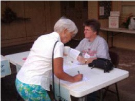 Flo Foerster signs up at recent Ministry Fair while April Smith looks for more volunteers.