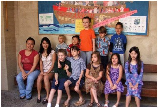 LCH children in front of the Ark bulletin board