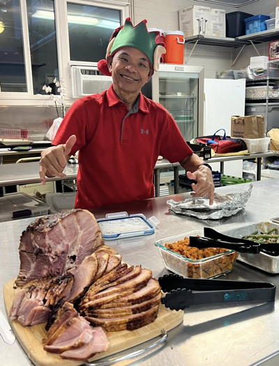 Rudy lends a helping hand and some holiday cheer at the Mary Magdalene Society potluck.