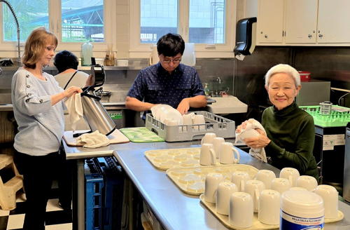 Liane, Nan, and Hunter clean together in the kitchen.