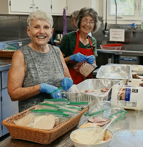 Cindy and Jeanne preparing bagged meals.