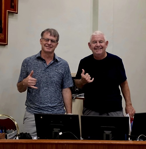 Rich and Dan throw shakas at the AV desk before worship.