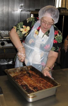 Olivia Castro cuts up meatloaf to server at IHS