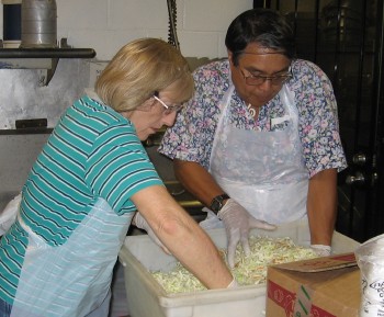 LCHers up to their elbows in salad as they prepare dinner at IHS