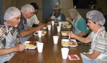 The crew enjoys the meatloaf after serving dinner at IHS