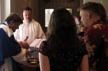 Pastor Lilley baptizes baby Steil.