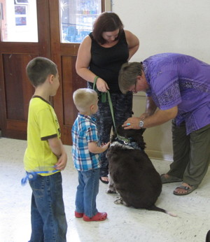 Pastor Jeff blesses the Heidenheimer's dog Zeus as the boys look on.